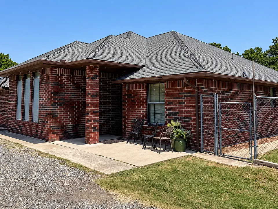 Finished brick home with a gray shingle roof