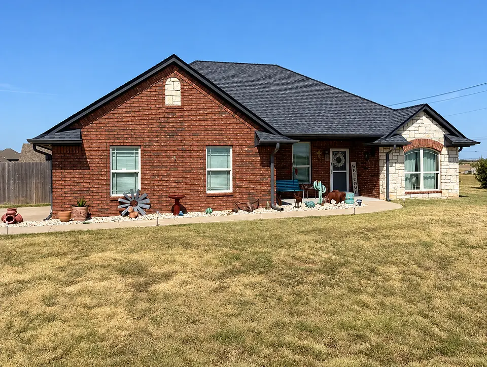 Finished brick and stone home with a dark shingle roof