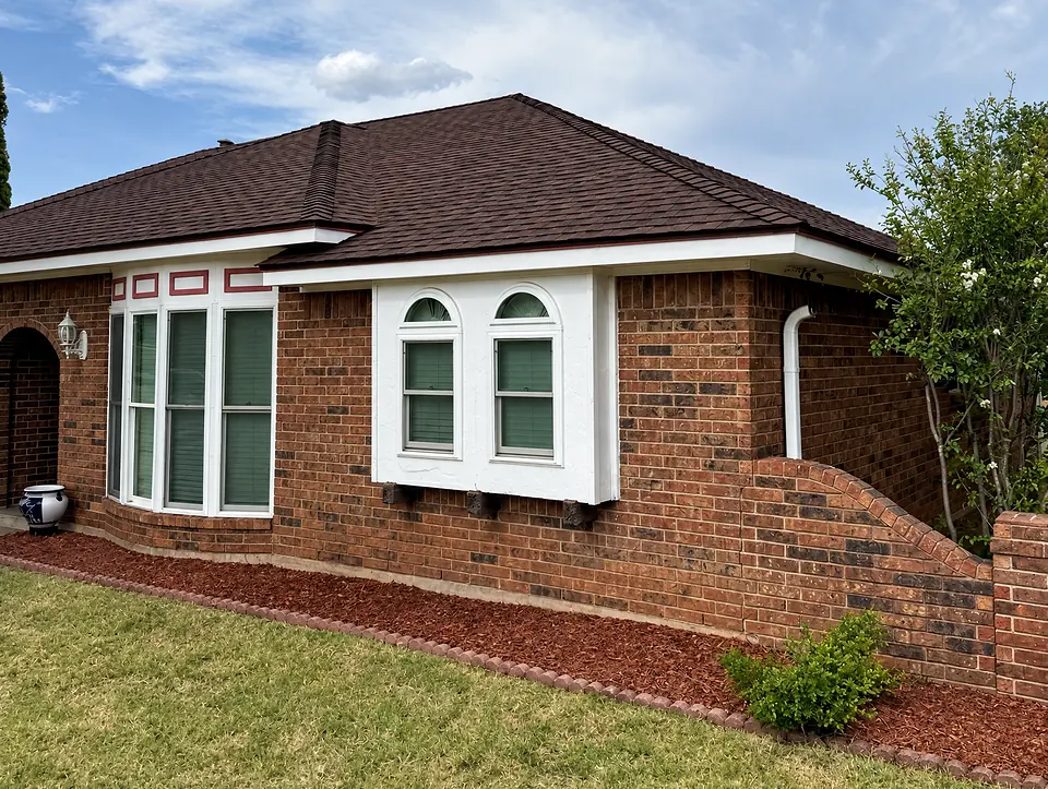 Finished brick home with a dark brown shingle roof