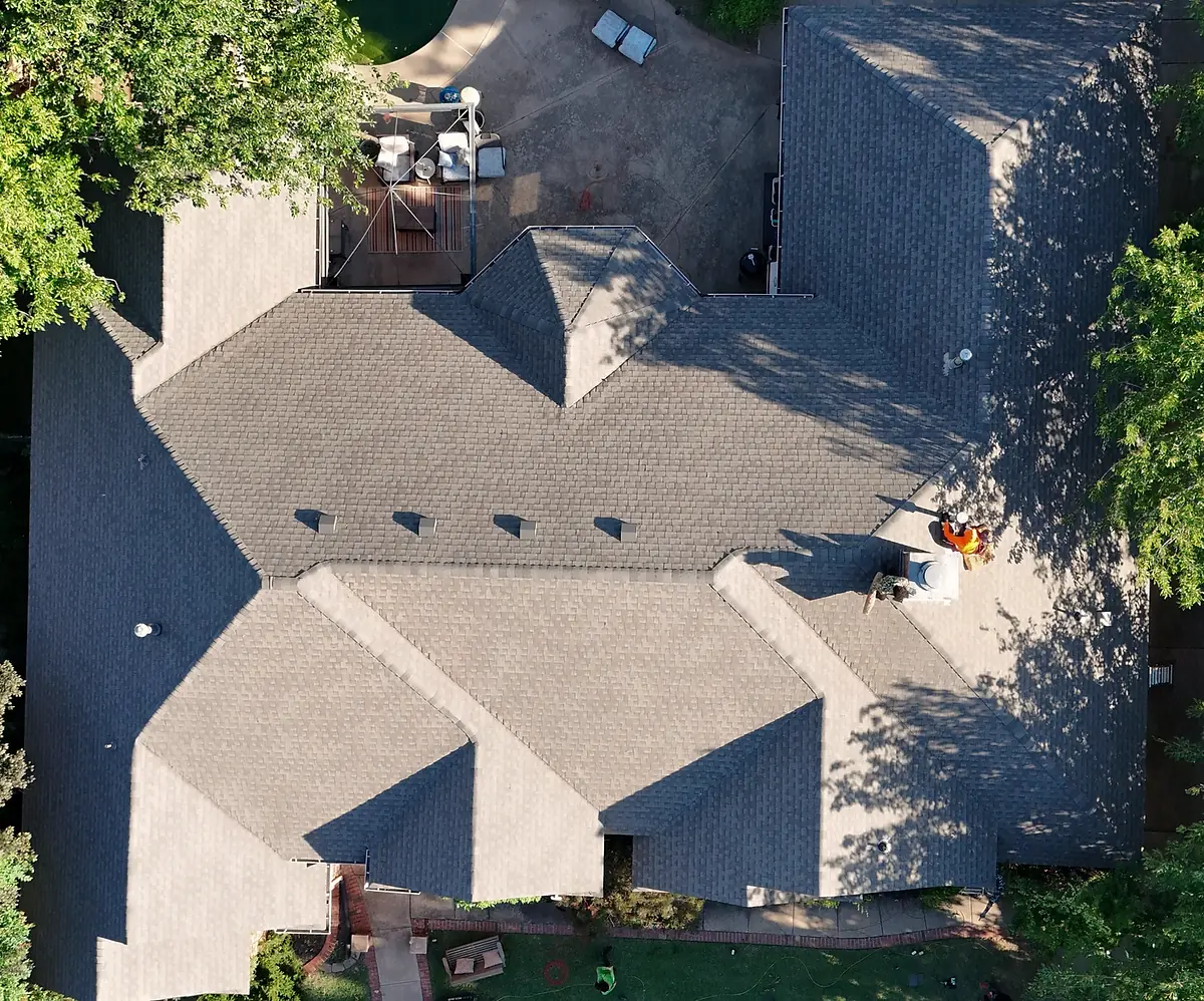 Aerial view of a residential roof with people working on it