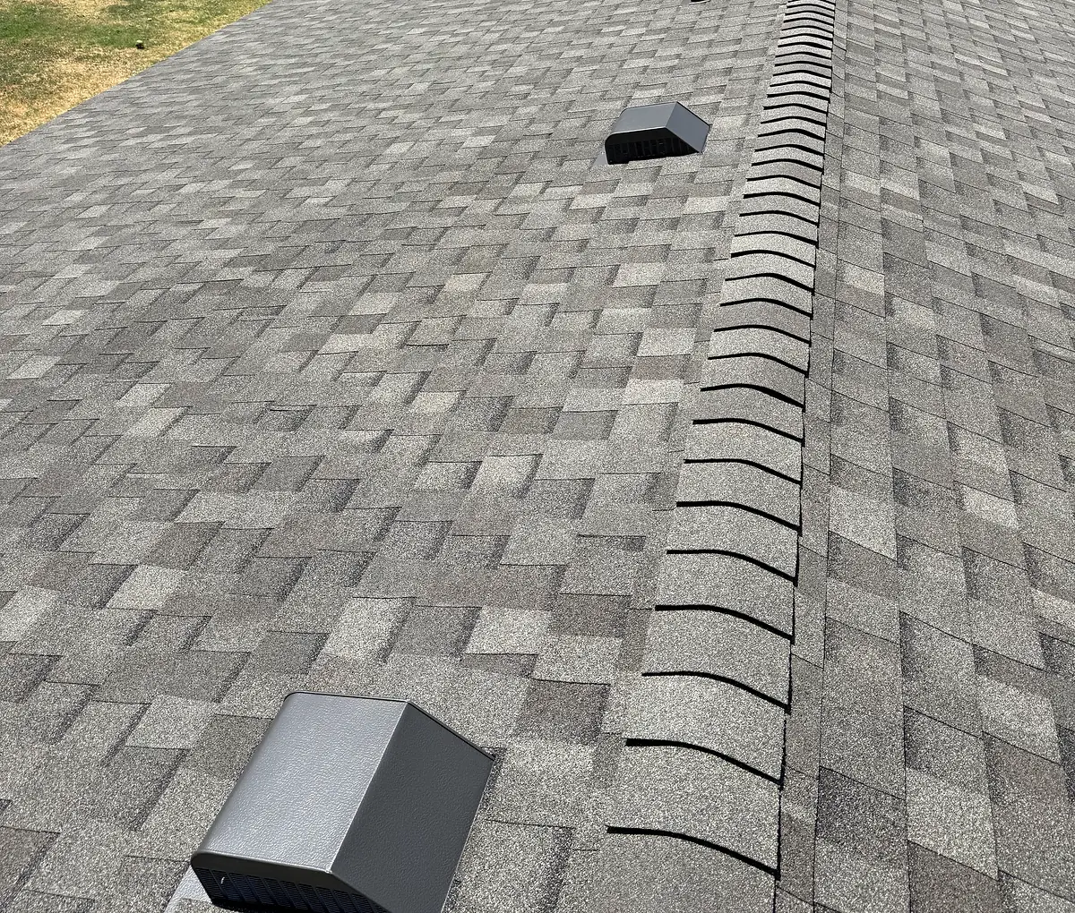Asphalt shingle roof with roof vents and a ridge cap