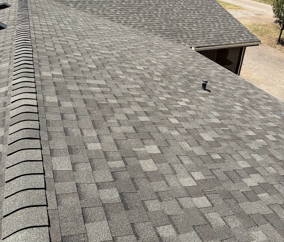 Asphalt shingle roof with a ridge cap and a roof vent