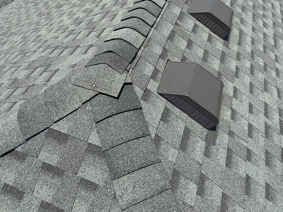 Shingle roof ridge cap beside a row of roof vents
